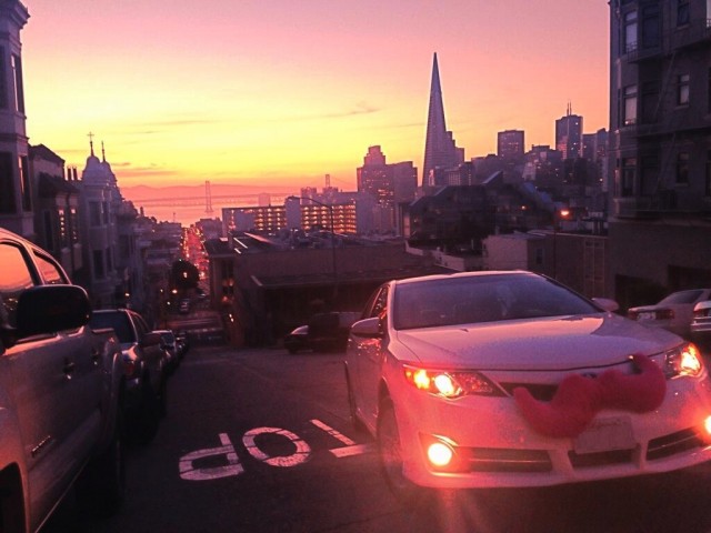 Lyft car with trademark pink mustache (via Wikimedia) 