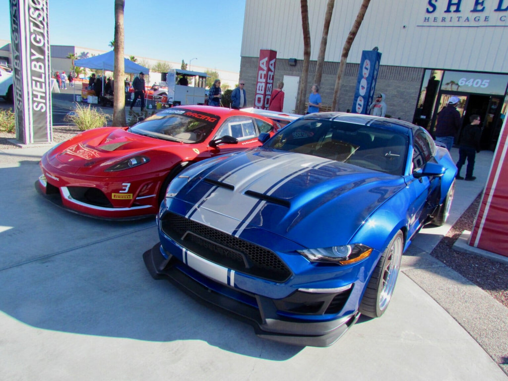A Ferrari racing car and a Shelby Super Snake Ford Mustang were parked in front of the Shelby Herita